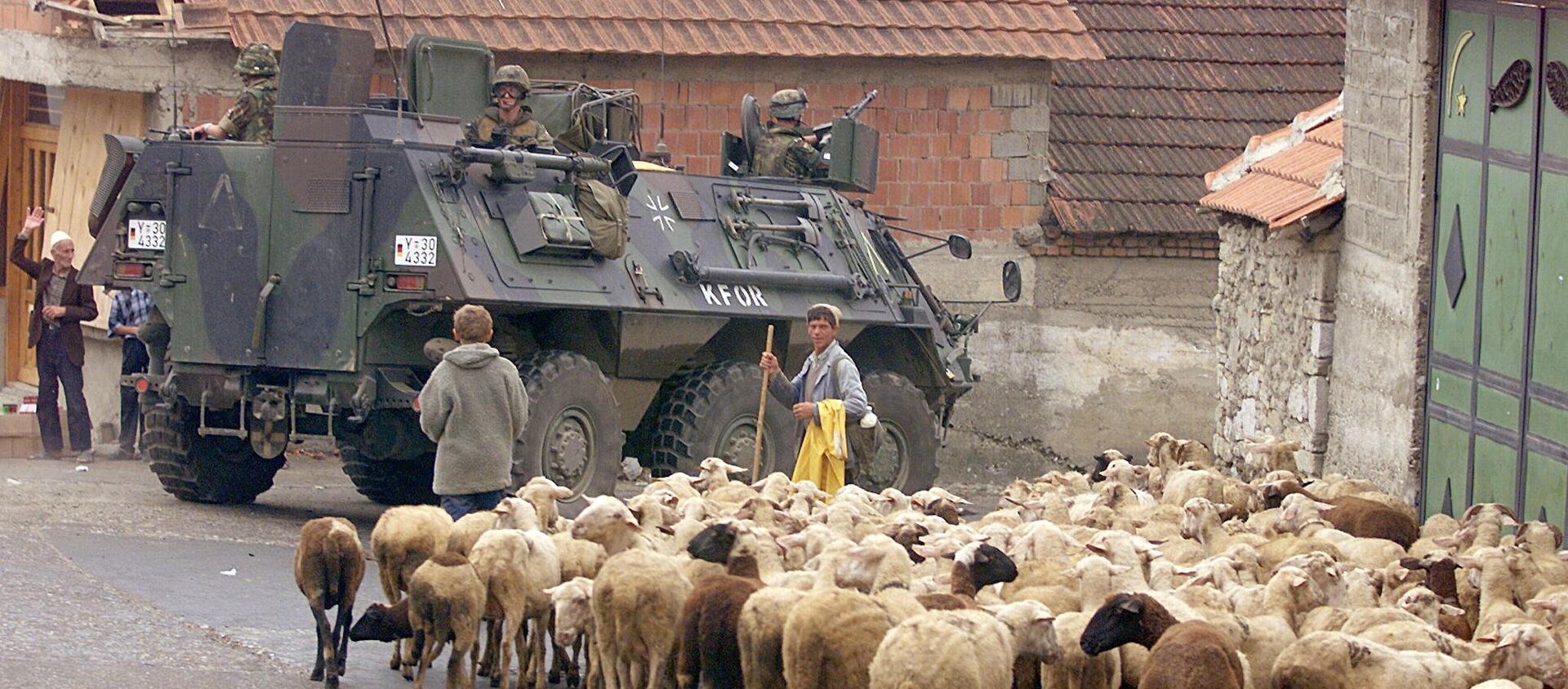 A German armoured vehicle part of the NATO-led KFOR troops drives past a herd of sheep 17 June 1999 in Orahovac, south western Kosovo. - Sputnik International, 1920, 21.04.2017
