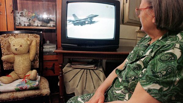 An unidentified Bosnian woman watches NATO air strikes against Yugoslav military targets on a TV screen in Tuzla, Bosnia, on Wednesday night, March 25, 1999. - Sputnik International