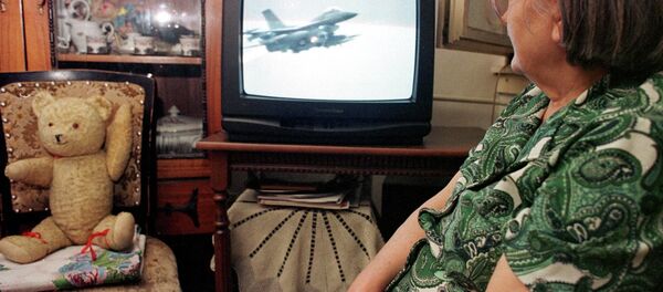 An unidentified Bosnian woman watches NATO air strikes against Yugoslav military targets on a TV screen in Tuzla, Bosnia, on Wednesday night, March 25, 1999. An unidentified Bosnian woman watches NATO air strikes against Yugoslav military targets on a TV screen in Tuzla, Bosnia, on Wednesday night, March 25, 1999. - Sputnik International