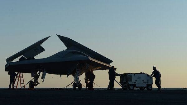 Sailors working on an X-47B Unmanned Combat Air System (UCAS) at dawn aboard the aircraft carrier USS George H.W. Bush - Sputnik International