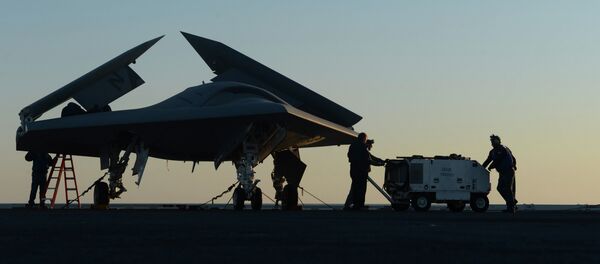 Sailors working on an X-47B Unmanned Combat Air System (UCAS) at dawn aboard the aircraft carrier USS George H.W. Bush Sailors working on an X-47B Unmanned Combat Air System (UCAS) at dawn aboard the aircraft carrier USS George H.W. Bush - Sputnik International