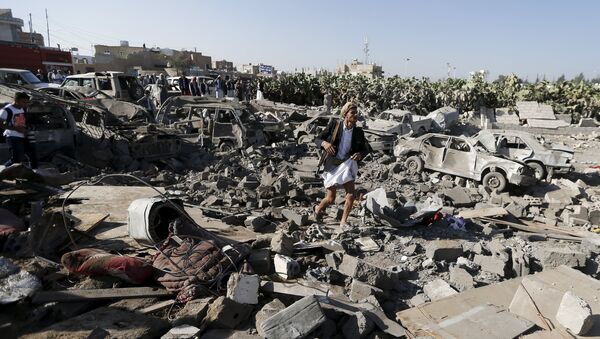 An armed man walks on the rubble of houses destroyed by an air strike near Sanaa Airport March 26, 2015. - Sputnik International