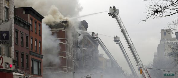 New York City Fire Department and Police stand by as firefighters fight a fire near where a residential apartment building collapsed and was engulfed in flames in New York City's East Village neighborhood New York City Fire Department and Police stand by as firefighters fight a fire near where a residential apartment building collapsed and was engulfed in flames in New York City's East Village neighborhood - Sputnik International