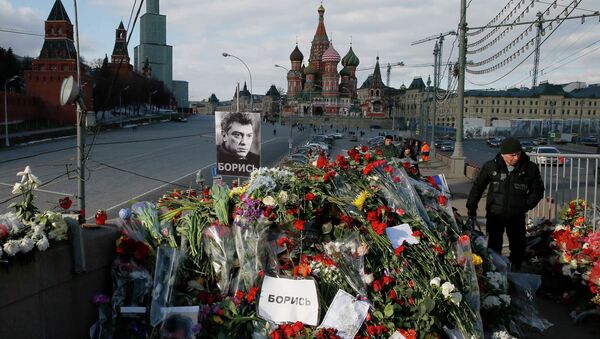 A man walks past flowers at the site where Kremlin critic Boris Nemtsov was murdered on February 27, at the Great Moskvoretsky Bridge, with St. Basil's Cathedral seen in the background, in central Moscow March 6, 2015 - Sputnik International