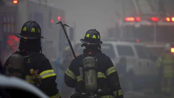 New York City Fire Department firefighters walk towards the site of a residential apartment building collapse and fire in New York City's East Village neighborhood - Sputnik International