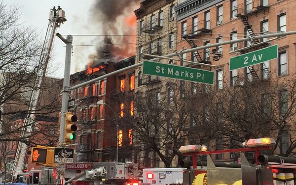 New York City firefighters work the scene of a large fire and a partial building collapse in the East Village neighborhood of New York - Sputnik International