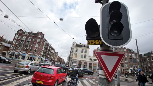 Cars and bicycles improvise crossing an intersection as traffic lights are off during a power outage in Amsterdam, Netherlands, Friday, March 27, 2015 - Sputnik International