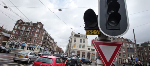 Cars and bicycles improvise crossing an intersection as traffic lights are off during a power outage in Amsterdam, Netherlands, Friday, March 27, 2015 Cars and bicycles improvise crossing an intersection as traffic lights are off during a power outage in Amsterdam, Netherlands, Friday, March 27, 2015 - Sputnik International