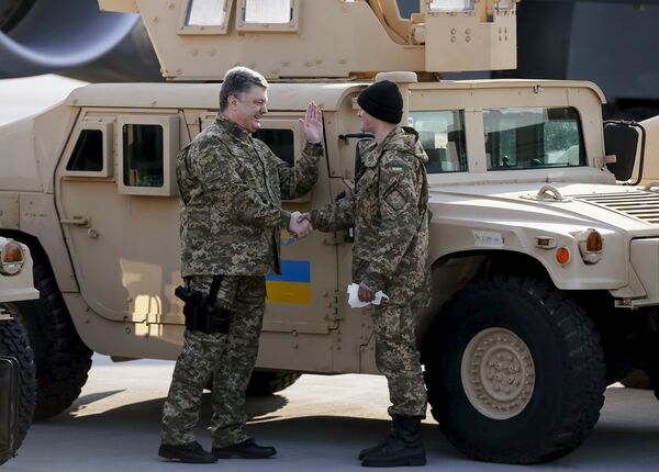 Ukraine's President Petro Poroshenko (L) welcomes a serviceman during a welcome ceremony for first plane from United State with non-lethal aid including ten Humvee vehicles to Ukraine at Borispol airport near Kiev, March 25, 2015 Ukraine's President Petro Poroshenko (L) welcomes a serviceman during a welcome ceremony for first plane from United State with non-lethal aid including ten Humvee vehicles to Ukraine at Borispol airport near Kiev, March 25, 2015 - Sputnik International
