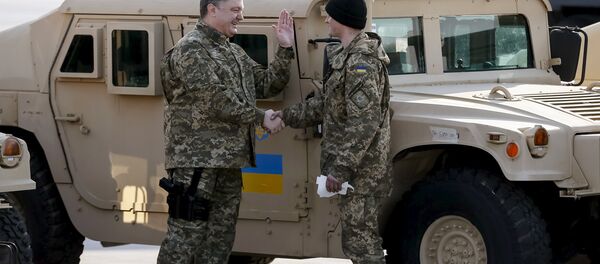 Ukraine's President Petro Poroshenko (L) welcomes a serviceman during a welcome ceremony for first plane from United State with non-lethal aid including ten Humvee vehicles to Ukraine at Borispol airport near Kiev, March 25, 2015 Ukraine's President Petro Poroshenko (L) welcomes a serviceman during a welcome ceremony for first plane from United State with non-lethal aid including ten Humvee vehicles to Ukraine at Borispol airport near Kiev, March 25, 2015 - Sputnik International