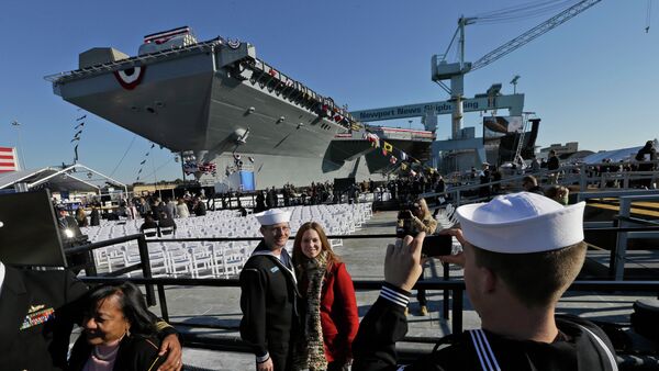 People pose for photos in front of Navy aircraft carrier USS Gerald R. Ford during the christening of the ship in November 2013. - Sputnik International