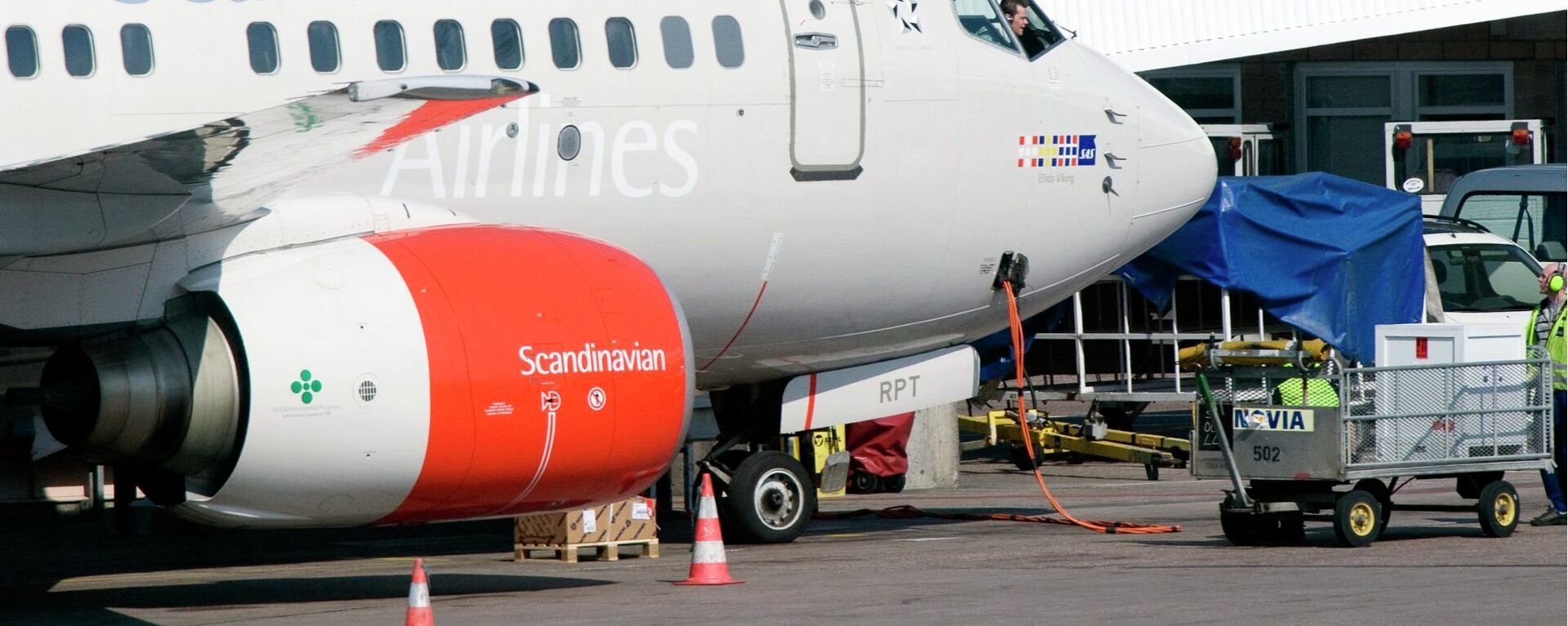 The pilot of an SAS Boeing 737 series jets speaks to his ground staff through the cockpit window at the gate of Terminal 4 on Arlanda airport in Stockholm, Sweden. File photo - Sputnik International, 1920, 28.05.2021