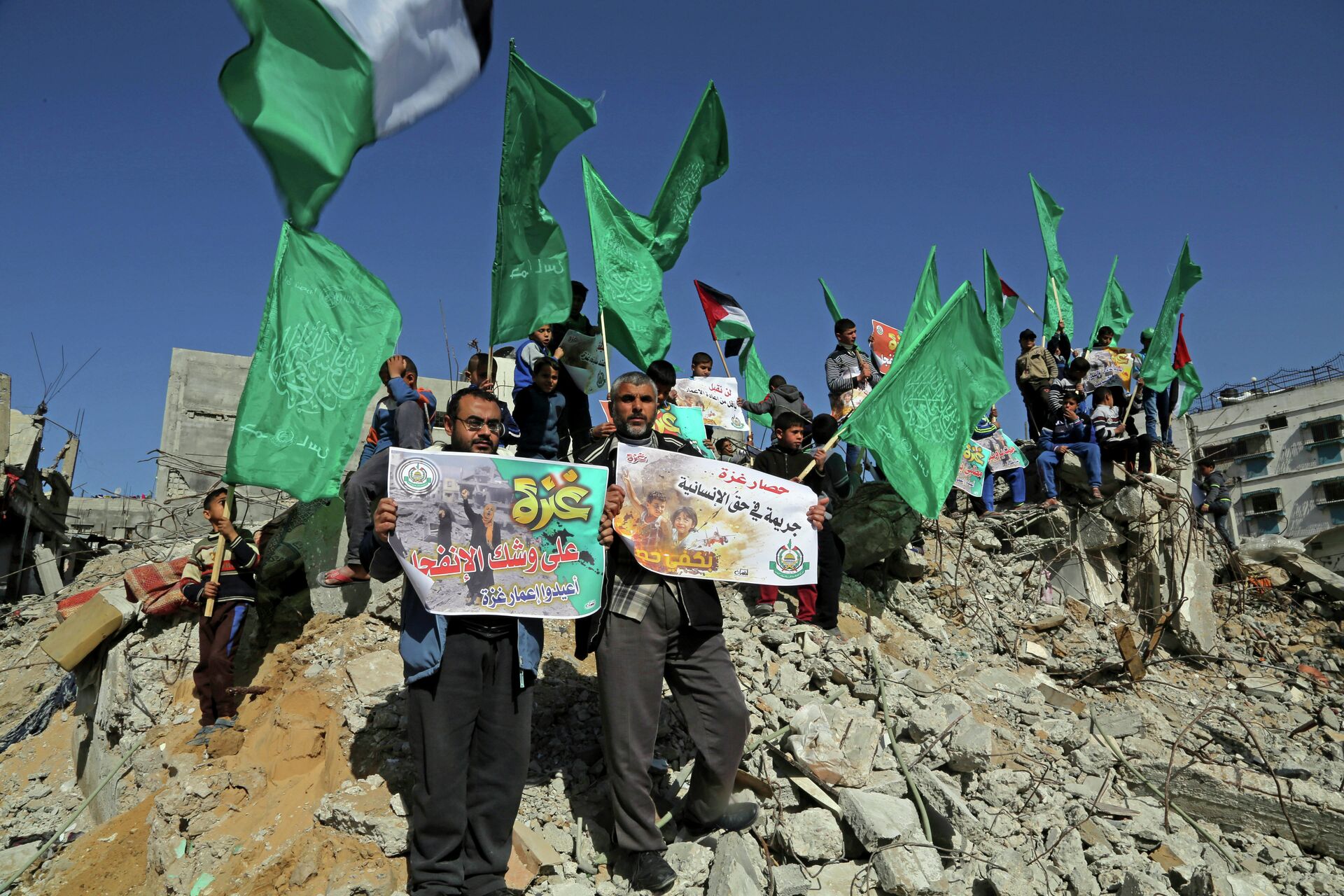 Palestinian Hamas supporters wave Hamas flags during a protest against the decision by the U.N. Relief and Works Agency to suspended an aid program for Gaza residents displaced by the last summer's war, in Beit Hanoun, northern Gaza. File photo - Sputnik International, 1920, 12.12.2021