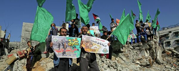Palestinian Hamas supporters wave Hamas flags during a protest against the decision by the U.N. Relief and Works Agency to suspended an aid program for Gaza residents displaced by the last summer's war, in Beit Hanoun, northern Gaza. File photo Palestinian Hamas supporters wave Hamas flags during a protest against the decision by the U.N. Relief and Works Agency to suspended an aid program for Gaza residents displaced by the last summer's war, in Beit Hanoun, northern Gaza. File photo - Sputnik International