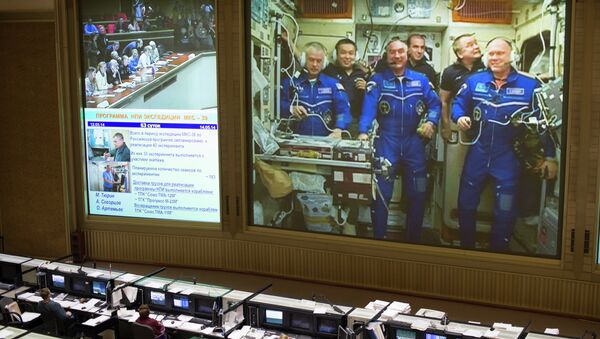 This view from Russian Mission Control Center shows live television of the Expedition 39 crew members gathered together on the International Space Station. - Sputnik International