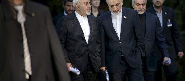 Iranian Foreign Minister Javad Zarif talks with Head of the Iranian Atomic Energy Organization Ali Akbar Salehi (C) after an afternoon meeting with U.S. Secretary of State John Kerry and U.S. officials at the Beau Rivage Palace Hotel in Lausanne March 27, 2015 - Sputnik International