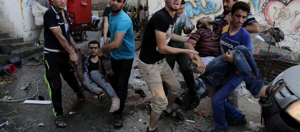 Palestinians help carry injured men following an Israeli Strike in Shijaiyah neighborhood, eastern Gaza City, last July. Palestinians help carry injured men following an Israeli Strike in Shijaiyah neighborhood, eastern Gaza City, last July. - Sputnik International