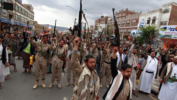 Shiite rebels, known as Houthis, hold up their weapons to protest against Saudi-led airstrikes, as they chant slogans during a rally in Sanaa, Yemen, Thursday, March 26, 2015 - Sputnik International
