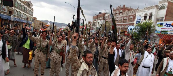Shiite rebels, known as Houthis, hold up their weapons to protest against Saudi-led airstrikes, as they chant slogans during a rally in Sanaa, Yemen, Thursday, March 26, 2015 - Sputnik International