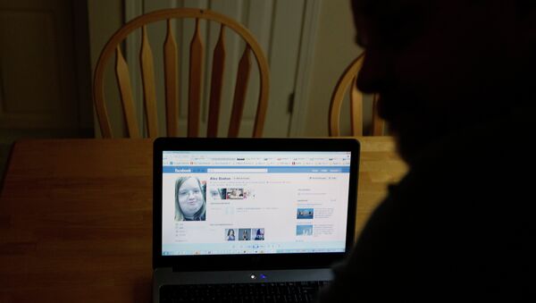 Chris Boston looks over a screen shot on his computer of the phony Facebook account that was set up in his daughter Alex's name Thursday, April 26, 2012, at their home in Acworth, Ga. - Sputnik International