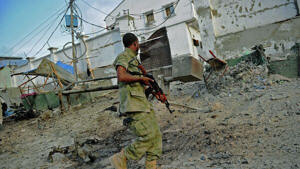 A solder walks past at the scene of a car bomb attack and armed raid by Al Shebab militants on the Maka al Mukarama hotel in Mogadishu - Sputnik International