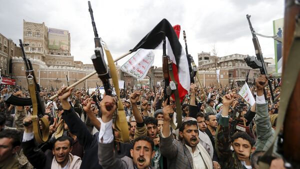 Shi'ite Muslim rebels hold up their weapons during a rally against air strikes in Sanaa March 26, 2015 - Sputnik International