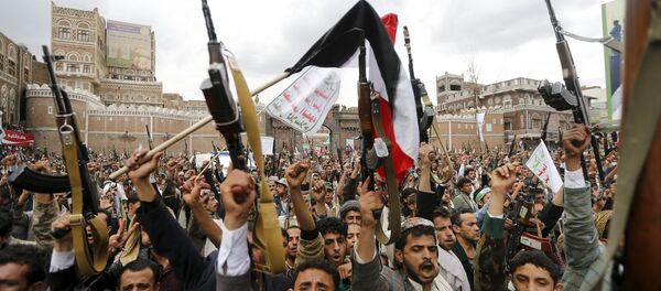 Shi'ite Muslim rebels hold up their weapons during a rally against air strikes in Sanaa March 26, 2015 - Sputnik International