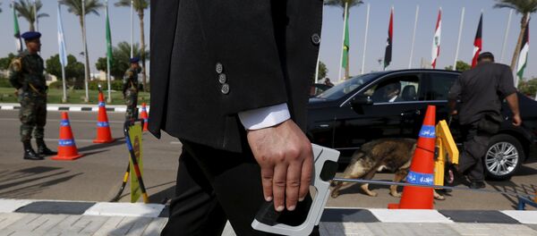 A plainclothes officer from Egypt's Republican Guard conducts a detection of explosive device search for explosives around a car ahead of the Arab Summit in Sharm el-Sheikh, in the South Sinai governorate, south of Cairo, March 28, 2015. - Sputnik International