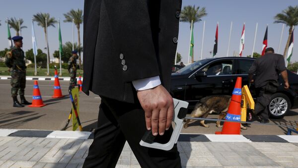 A plainclothes officer from Egypt's Republican Guard conducts a detection of explosive device search for explosives around a car ahead of the Arab Summit in Sharm el-Sheikh, in the South Sinai governorate, south of Cairo, March 28, 2015. - Sputnik International