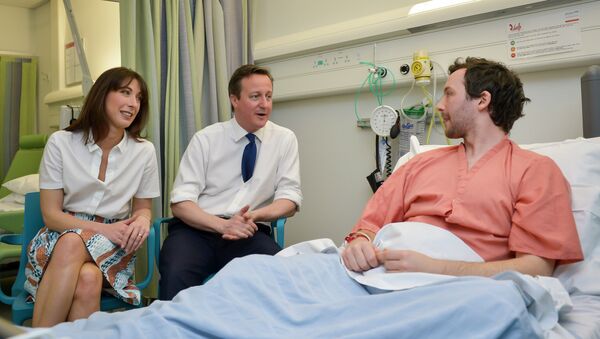 British Prime Minister and Conservative party leader David Cameron (C) and his wife Samantha speak with a patient at his bedside on a visit to Salford Royal Hospital in Manchester on March 28, 2015 - Sputnik International