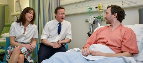British Prime Minister and Conservative party leader David Cameron (C) and his wife Samantha speak with a patient at his bedside on a visit to Salford Royal Hospital in Manchester on March 28, 2015 British Prime Minister and Conservative party leader David Cameron (C) and his wife Samantha speak with a patient at his bedside on a visit to Salford Royal Hospital in Manchester on March 28, 2015 - Sputnik International