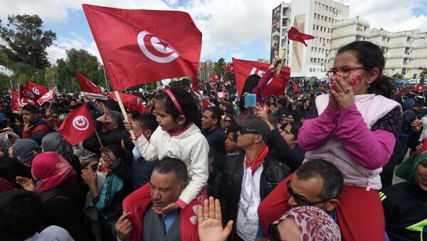 Tunisians wave their national flag and chant slogans during a march against extremism outside Tunis' Bardo Museum on March 29, 2015 - Sputnik International