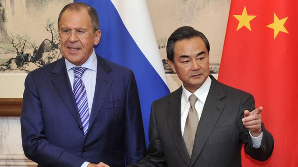 Russian Foreign Minister Sergey Lavrov (L) shakes hands with Chinese Foreign Minister Wang Yi before their meeting at Diaoyutai Guesthouse in Beijing on April 15, 2014 - Sputnik International