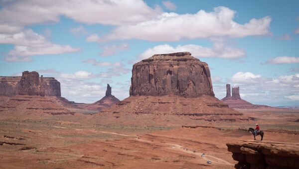 A Navajo man on a horse poses for tourists in front of the Merrick Butte in Monument Valley Navajo Tribal park, Utah, on May 12, 2014 - Sputnik International