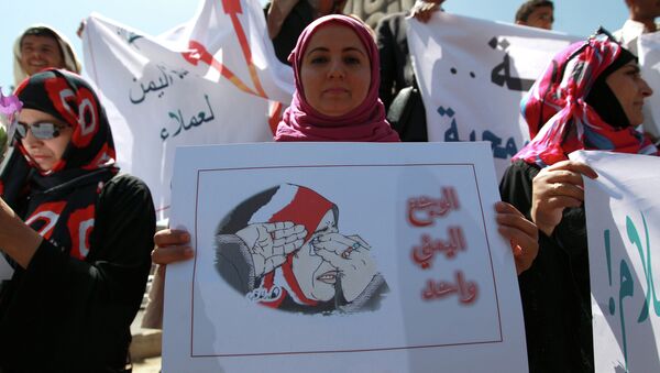 A Yemeni woman holds a poster during a rally against Saudi-led coalition airstrikes against Huthi rebels on March 29, 2015 in Sanaa - Sputnik International