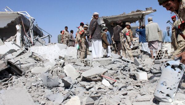 Soldiers and Houthi fighters inspect the damage caused by air strikes on the airport of Yemen's northwestern city of Saada, a Houthi stronghold near the Saudi border, March 30, 2015 - Sputnik International