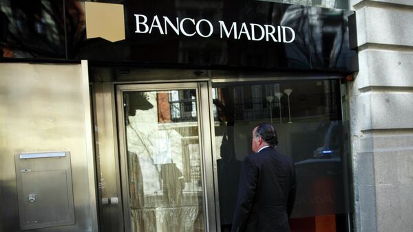 A man stands in front of the entrance of a closed Banco Madrid branch in Madrid, March 16, 2015 - Sputnik International