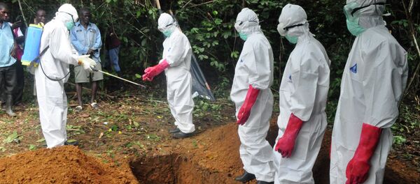 A burial team in protective gear spray each other with disinfectant after burying the body of woman suspected to have died from Ebola virus in Monrovia, Liberia A burial team in protective gear spray each other with disinfectant after burying the body of woman suspected to have died from Ebola virus in Monrovia, Liberia - Sputnik International