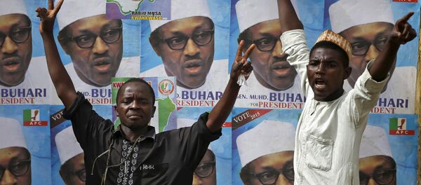 Supporters of presidential candidate Muhammadu Buhari gesture in front of his election posters in Kano Supporters of presidential candidate Muhammadu Buhari gesture in front of his election posters in Kano - Sputnik International
