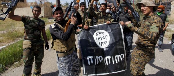 Iraqi security forces and Shi'ite paramilitary fighters hold an Islamist State flag, which they pulled down in Tikrit, March 31, 2015. - Sputnik International