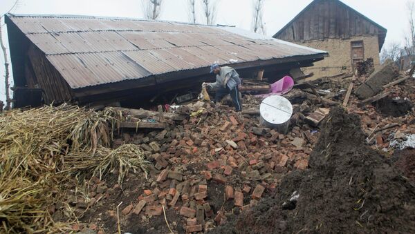 A Kashmiri villager inspects a damaged house following landslides - Sputnik International
