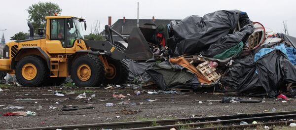 An excavator destroys makeshift shelters An excavator destroys makeshift shelters - Sputnik International
