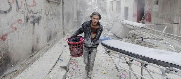 A boy carries his belongings at a site hit by what activists said was a barrel bomb dropped by forces loyal to Syria's President Bashar al-Assad in Aleppo's al-Fardous district A boy carries his belongings at a site hit by what activists said was a barrel bomb dropped by forces loyal to Syria's President Bashar al-Assad in Aleppo's al-Fardous district - Sputnik International