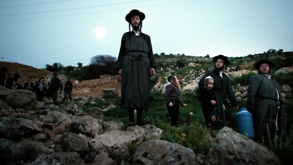 Ultra-Orthodox Jews leave the site after collecting water from a mountain spring near Jerusalem to be used in baking unleavened bread, known as Matzoth, during the Maim Shelanu (Rested Water) ceremony on April 2, 2015. - Sputnik International