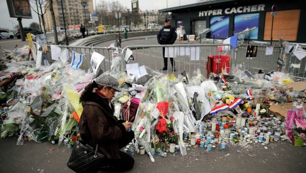 A woman lighting a candle outside the kosher grocery where Amedy Coulibaly killed four people in a terror attack, in Paris, France. - Sputnik International