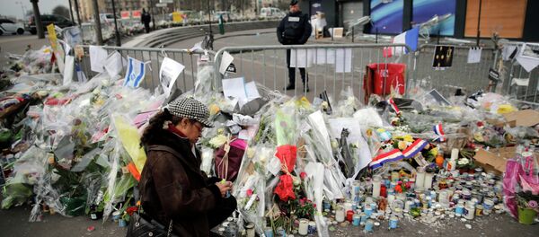 A woman lighting a candle outside the kosher grocery where Amedy Coulibaly killed four people in a terror attack, in Paris, France. A woman lighting a candle outside the kosher grocery where Amedy Coulibaly killed four people in a terror attack, in Paris, France. - Sputnik International