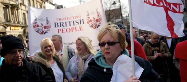 Protesters from the UK branch of the German group 'Pegida' hold a banner reading 'Protecting British People' as they demonstrate in the city centre of Newcastle upon Tyne, Northern England on February 28, 2015 - Sputnik International