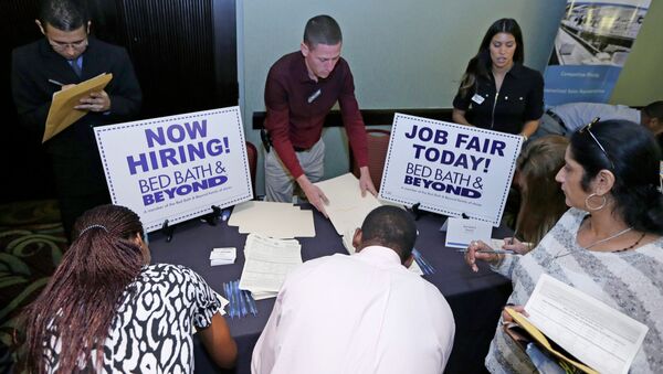 In this Oct. 22, 2014 file photo, job seekers fill out a job applications at a Bed Bath and Beyond table at a job fair in Miami Lakes, Fla. - Sputnik International