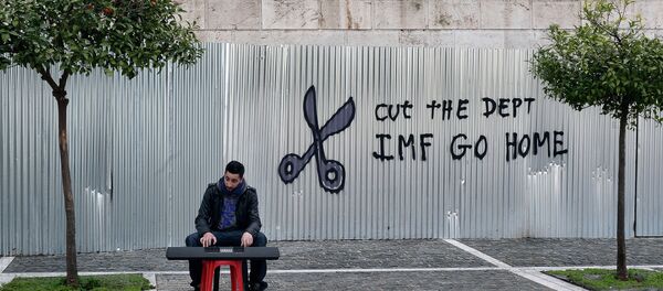 A man plays music on a digital keyboard near graffiti on a corrugated metal gate reading Cut the debt, IMF go home in Athens on February 24, 2015 A man plays music on a digital keyboard near graffiti on a corrugated metal gate reading Cut the debt, IMF go home in Athens on February 24, 2015 - Sputnik International