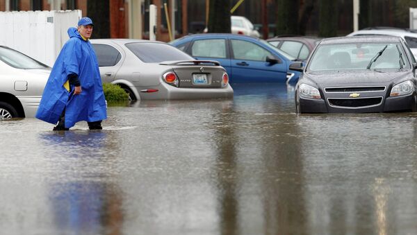 A resident of the Guardian Court Apartments wades through high water after heavy rains caused flash flooding and forced some to leave their homes in Louisville, Kentucky - Sputnik International